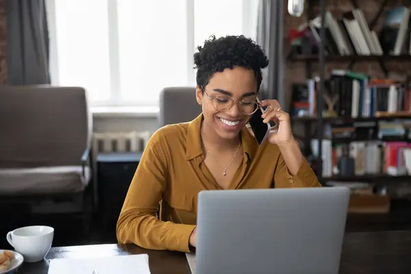 Glad afro amerikansk kontorsarbetare i glasögon svara telefonsamtal — Stockfoto