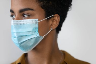 Yüz maskesi takan güzel Afro-Amerikan kadın.
