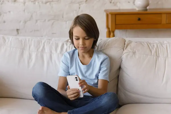 Fokusert tenåring som leser Internett på mobiltelefon hjemme – stockfoto