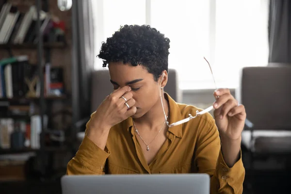 Moe jonge Afrikaanse freelance werknemer moe van het werk op laptop — Stockfoto