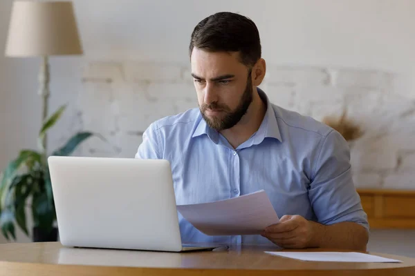 Gerichte duizendjarige zakenman die papieren rapporten controleert — Stockfoto