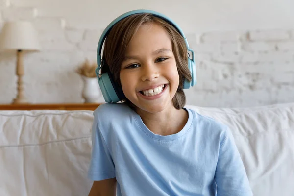 Happy school kind jongen in grote koptelefoon kijken naar camera — Stockfoto