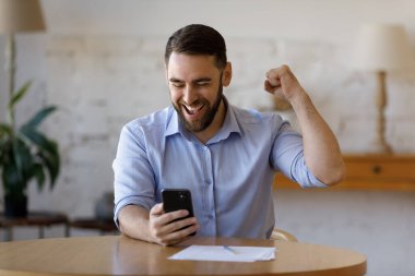 Mutlu heyecanlı akıllı telefon kullanıcısı kazanmanın, başarmanın, başarmanın tadını çıkarıyor.