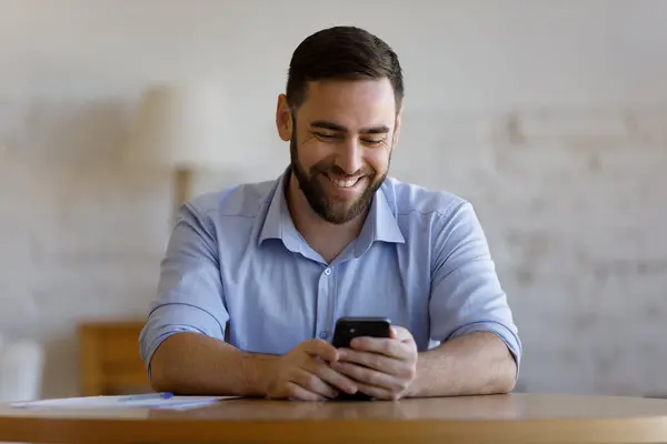 Happy millennial zakenman chatten online met klant op smartphone — Stockfoto