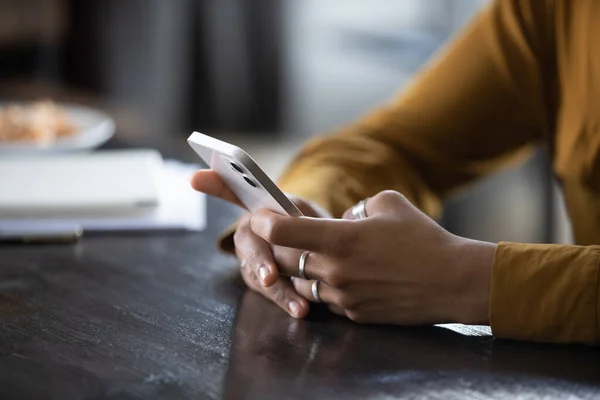 Руки молодой темнокожей женщины с помощью приложения по телефону — стоковое фото