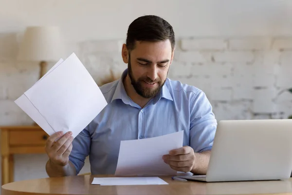 Tevreden lachende zakenman doet papierwerk thuis — Stockfoto