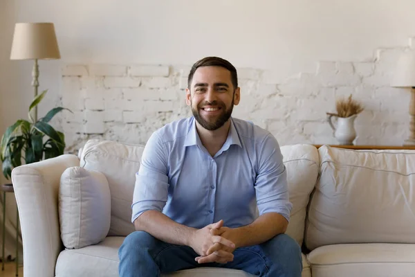 Щасливий бородатий молодий хлопець робить відеодзвінок з дому — стокове фото