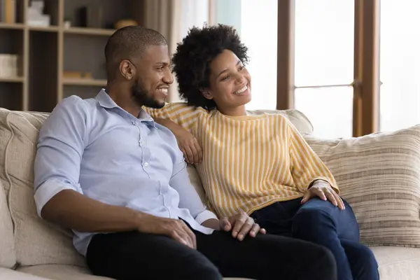 Pareja de ensueño sentarse en el sofá soñando despierto mirando a la distancia —  Fotos de Stock