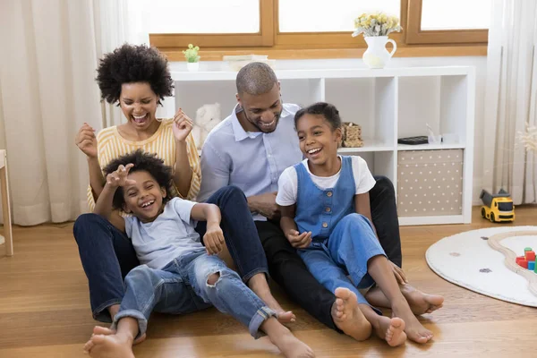 Smějící se africké páry a děti sedět v jeslích doma — Stock fotografie