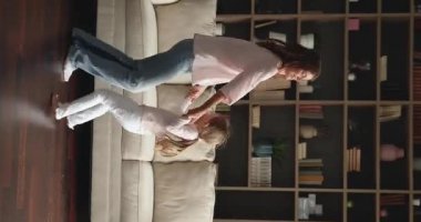 Evde dans eden anne ve küçük kızın dikey görüntüsü