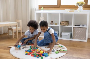 Afrikalı çocuklar evlerinde sıcak zeminde oturup küp oynuyorlar.