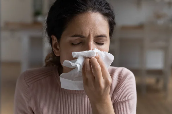 Unhealthy Latina woman blows runny nose in napkin, closeup — Stock Photo, Image