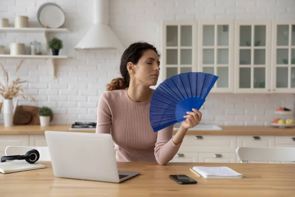Woman feels overheated cools herself with hand fan — Stock Photo, Image