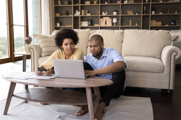 Pareja africana seria que paga facturas en línea, calcula gastos en casa — Foto de Stock