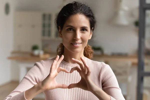 Mulher latina faz gesto símbolo do coração com os dedos unidos — Fotografia de Stock