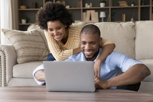 Afrikaans paar zitten in woonkamer veel plezier gebruik laptop — Stockfoto