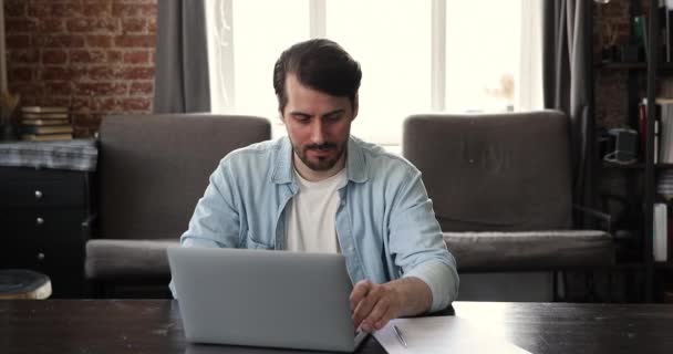 Porträtt ung affärsman frilansare arbetar från hemmakontoret på bärbar dator — Stockvideo