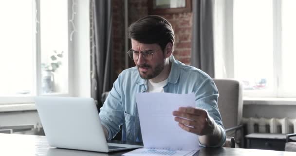 Homem milenar irritado gerenciar documentos financeiros surpreso com más notícias — Vídeo de Stock