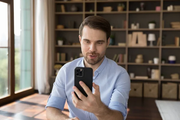 Feliz joven empresario confiado sosteniendo videollamada móvil. — Foto de Stock