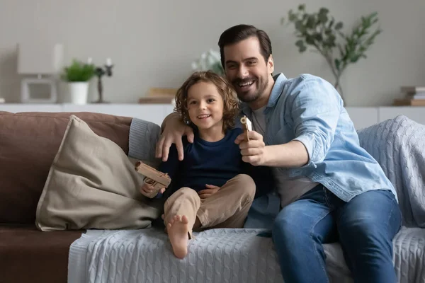 Baba ve oğul evde oyuncak silah oyunu oynuyorlar.