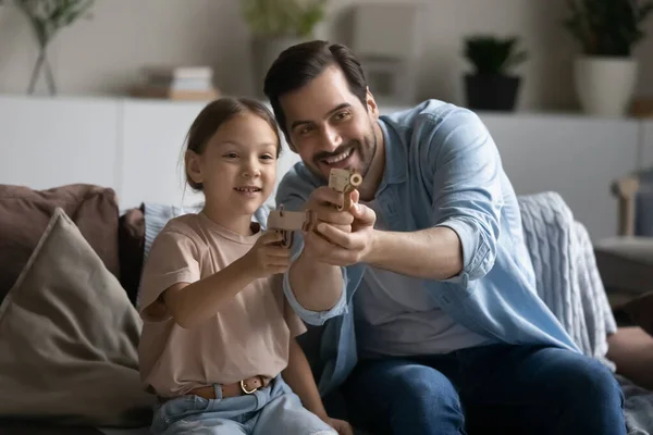 Little daughter and dad playing toy guns at home — Stock Photo, Image