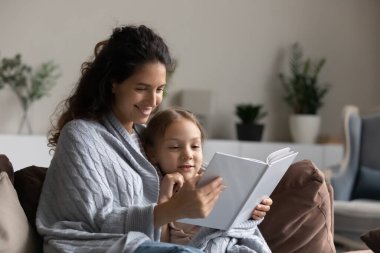 Sevgili anne kızına bir kitap okuyor.