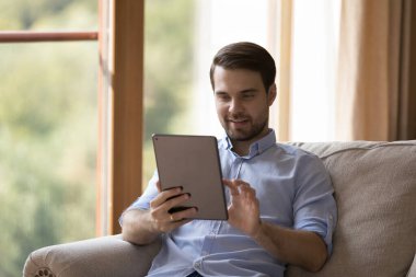 Dijital bilgisayar tableti kullanan neşeli milenyum adamı.