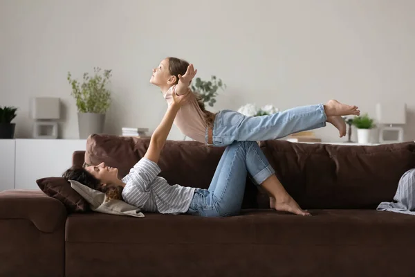 Mom lifts daughter, enjoy active sporty playtime at home — Stock Photo, Image