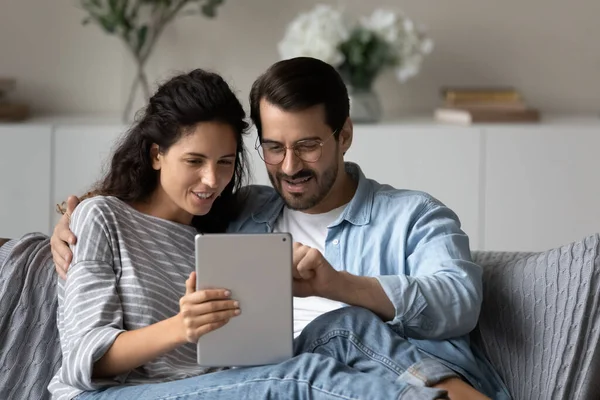 Paar sitzt auf Sofa und kauft digitales Tablet im Internet — Stockfoto