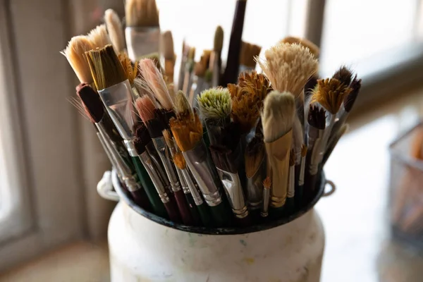 Bunch of paint brushes in metal bucket close up