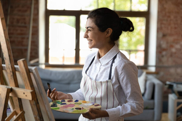 Счастливая веселая молодая индийская художница чувствует радость