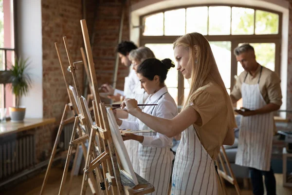 Многонациональная группа студентов художественных школ рисует красками — стоковое фото