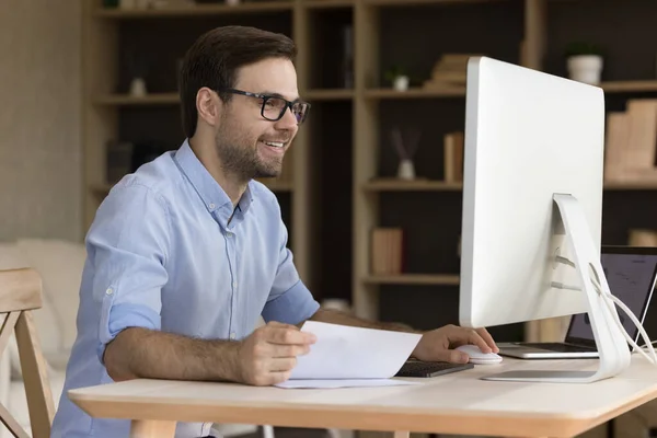Jovem empresário feliz em óculos trabalhando no escritório em casa. — Fotografia de Stock