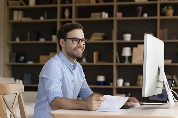 Sonriente guapo millennial empleado trabajando en casa oficina. — Foto de Stock