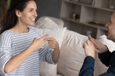 İşaret dili kullanan, gülümseyen İspanyol kadın.