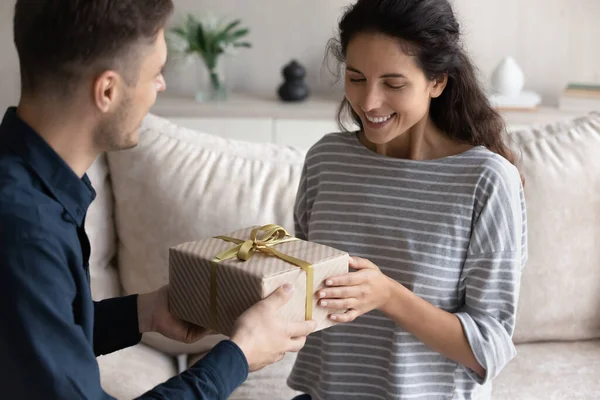 Älskade pojkvän gratulerar leende flickvän, ger presentförpackning — Stockfoto