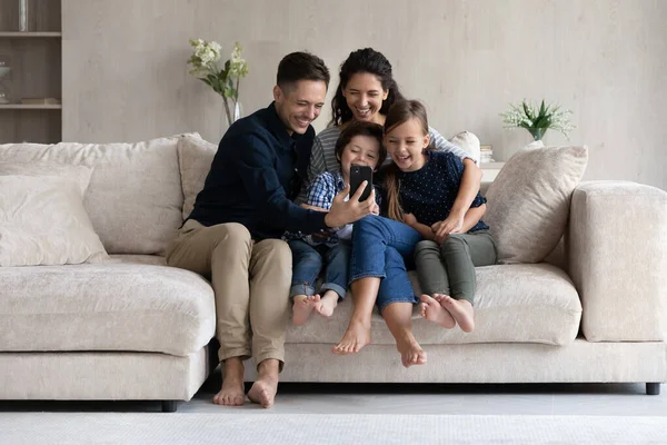 Glückliche Eltern und Kinder haben Spaß mit Smartphone zu Hause — Stockfoto