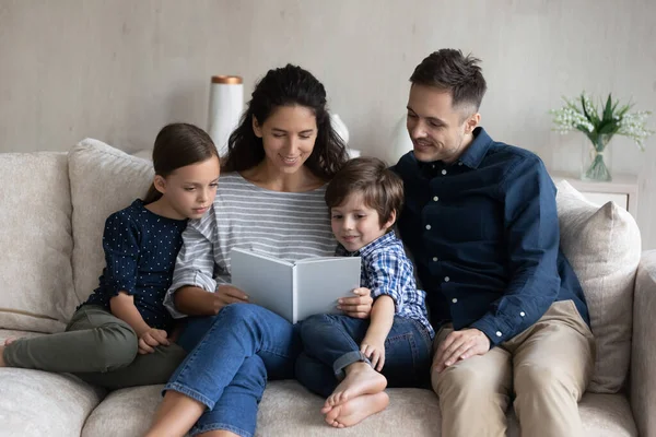 Joyeux livre de lecture en famille ensemble, relaxant sur le canapé — Photo