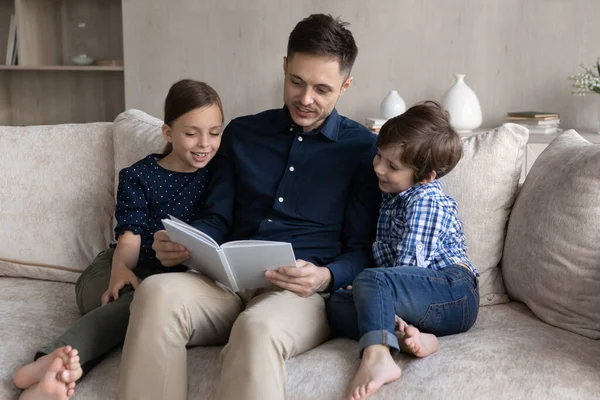 Père aimant lisant le livre au petit fils et à la fille — Photo