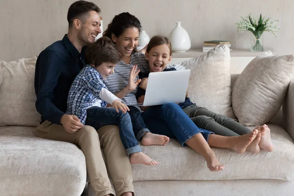 Parents heureux avec deux enfants faisant appel à la vidéo ensemble — Photo