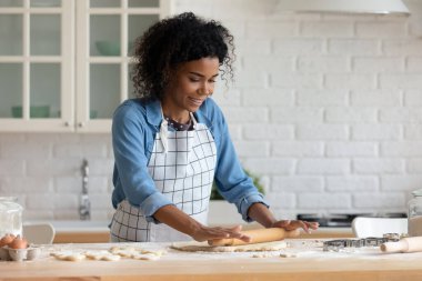 Gülümseyen güzel Afro-Amerikan kadın pasta hazırlıyor..
