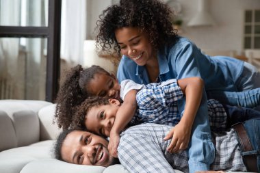 Gülümseyen Afrikalı Amerikalı aile hafta sonunu evde kaygısızca geçiriyor..