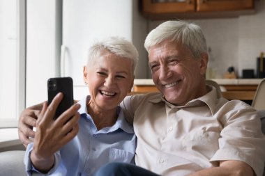 Mutlu son sınıf çifti cep telefonuyla selfie çekiyor.