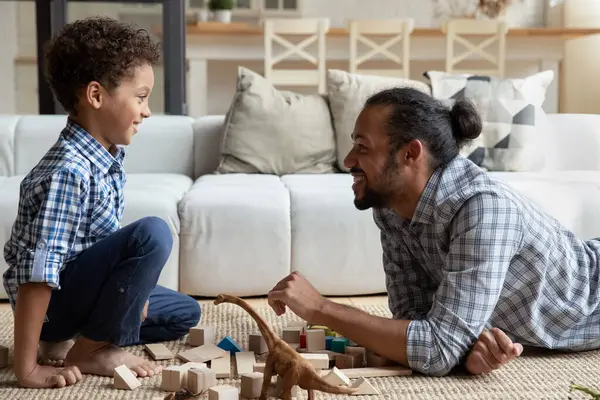 Joyful menino afro-americano brincando brinquedos com o pai. — Fotografia de Stock