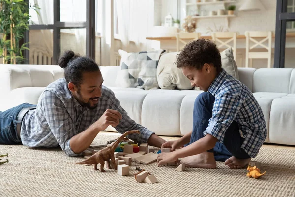 Gelukkig zorgzame jonge Afro-Amerikaanse vader spelen speelgoed met zoon. — Stockfoto