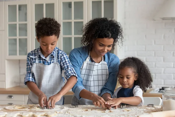 幸せなアフリカ系アメリカ人の母親クッキーを作る子供たち. — ストック写真