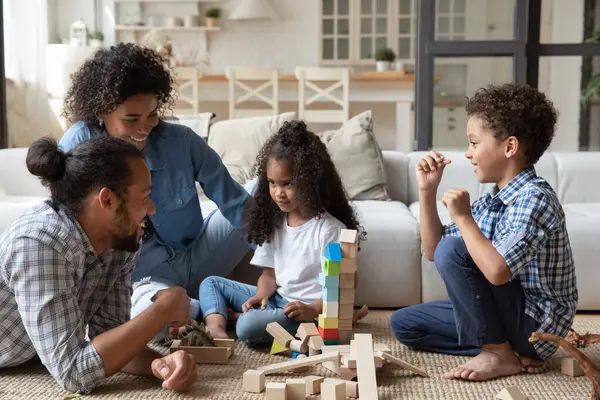 Gelukkig afrikaanse amerikaanse familie spelen speelgoed thuis. — Stockfoto