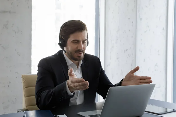 Vážné podnikání profesionální muž ve sluchátkách s mikrofonem pomocí notebooku — Stock fotografie
