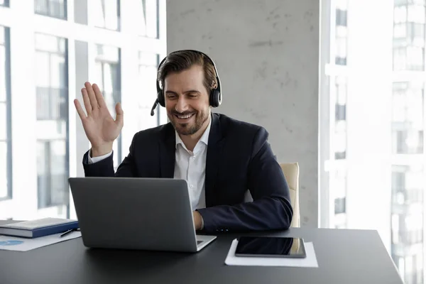 Gelukkig zakenman in koptelefoon houden van online virtuele conferentie — Stockfoto