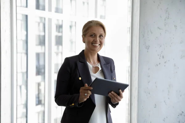 Happy successful middle aged businesswoman holding tablet — Stock Photo, Image